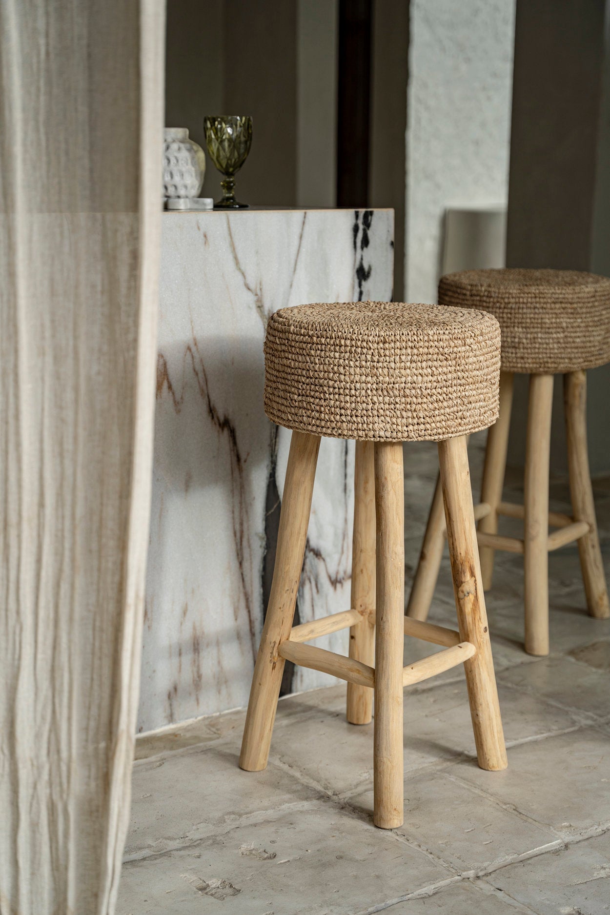 De raffia barstoel