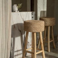 De raffia barstoel